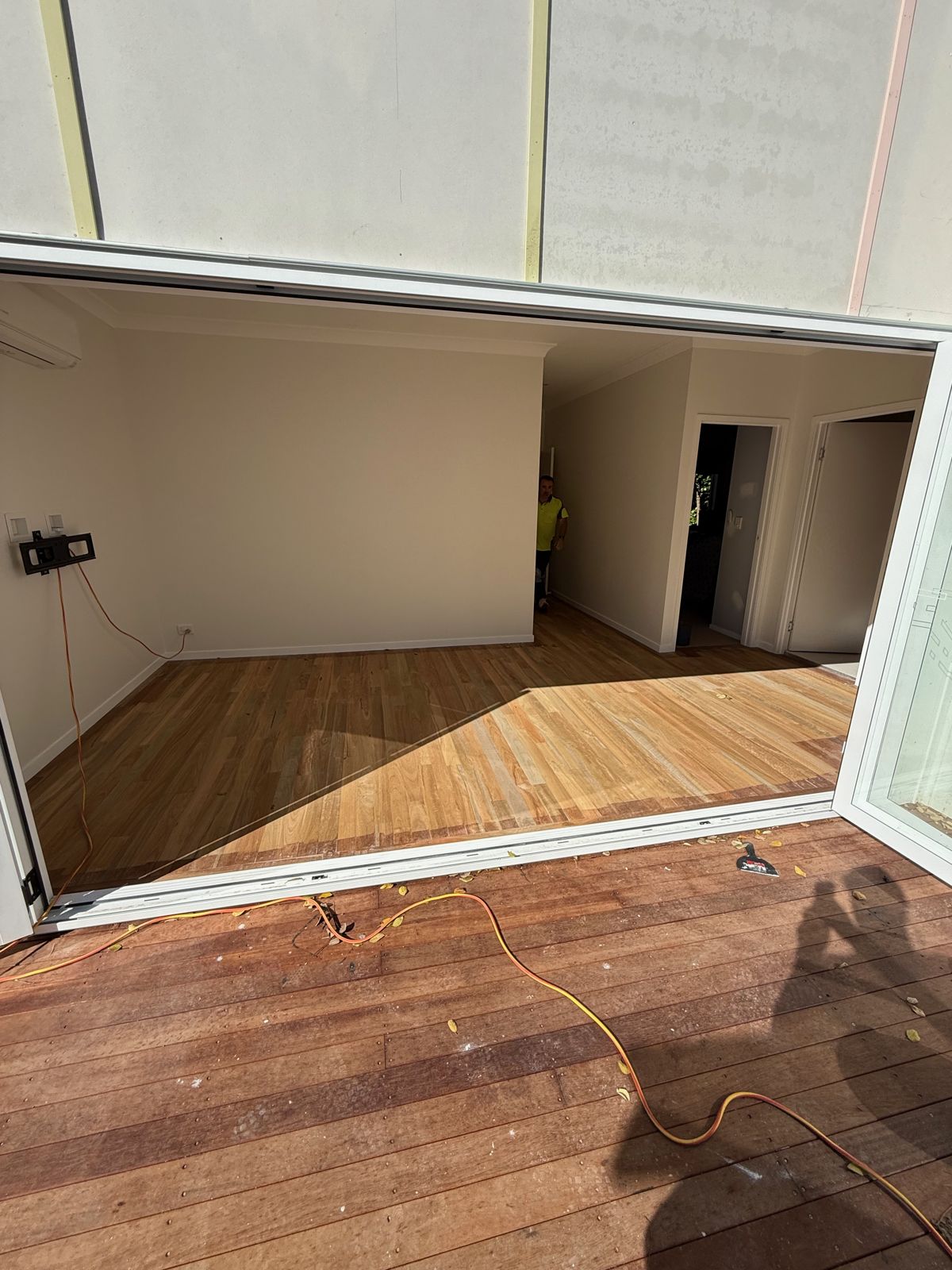 Finished hardwood floors running from the deck through open doors into the living room